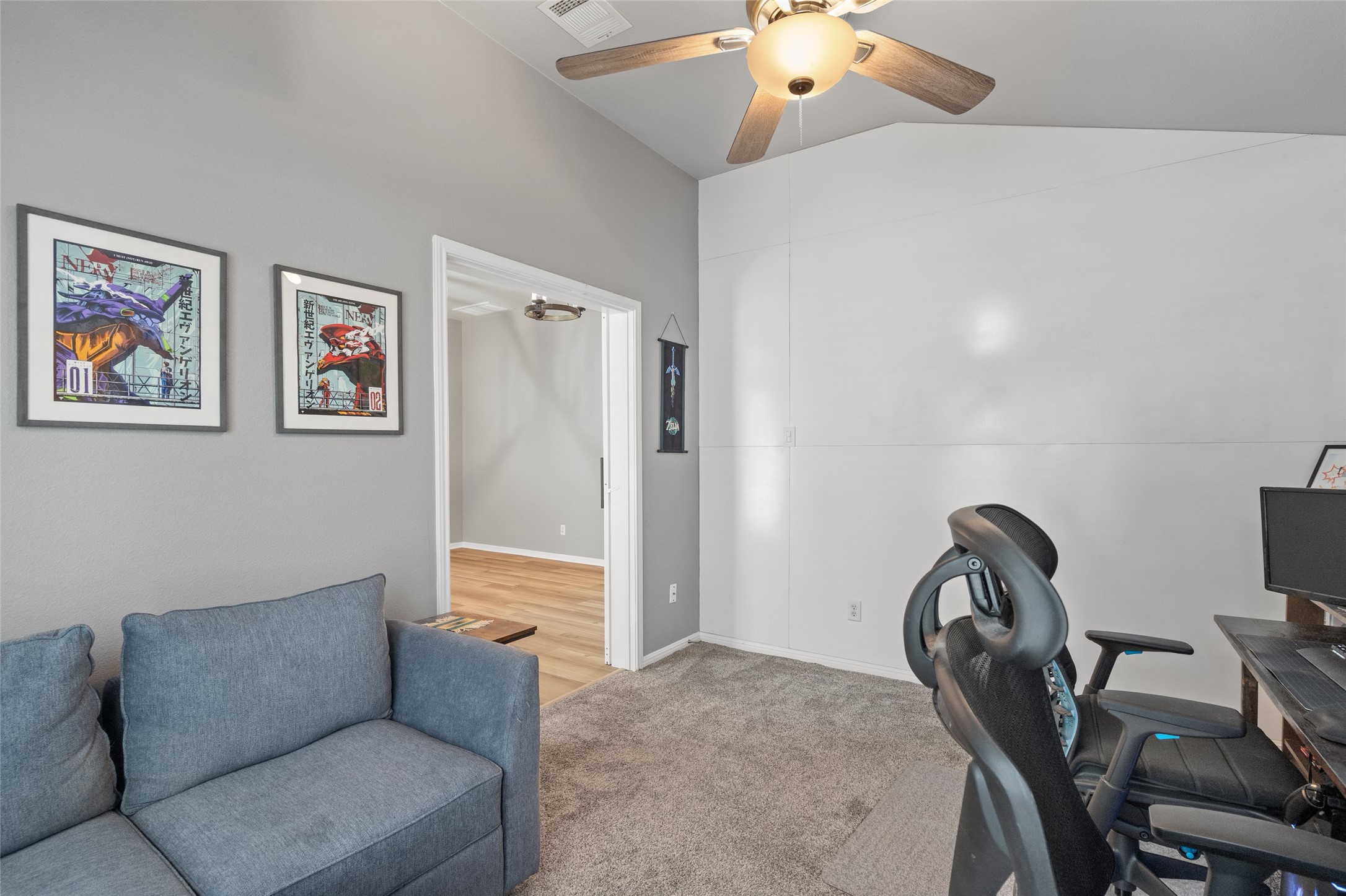 7013 Cromarty Lane Austin, TX 78754 - Photo 9 of 37 This room features a vaulted ceiling with a ceiling fan, carpet flooring, and a doorway leading to a room with hardwood flooring