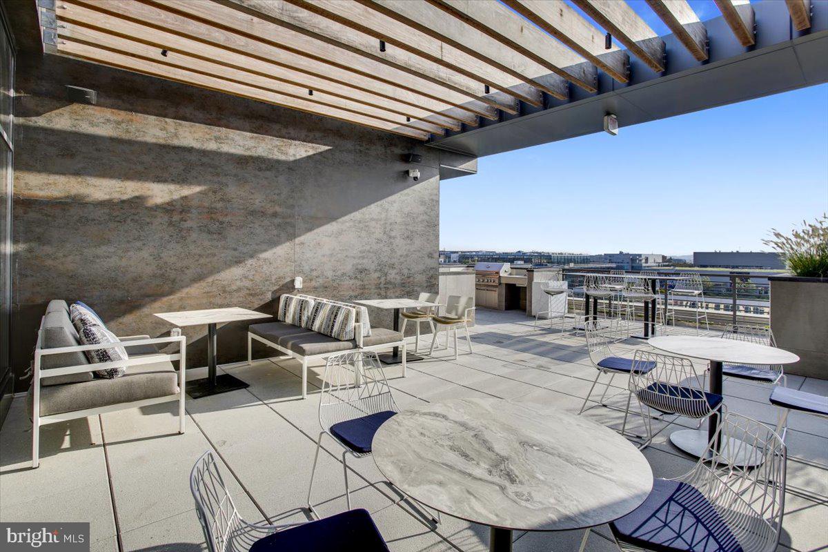 1211 Van Street Southeast, Unit 902 Washington, DC 20003 - Photo 21 of 43 a view of a patio with couches table and chairs with wooden floor