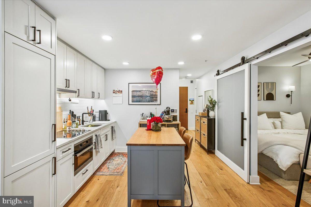 1211 Van Street Southeast, Unit 902 Washington, DC 20003 - Photo 8 of 43 a kitchen view with wooden floor and stainless steel appliances