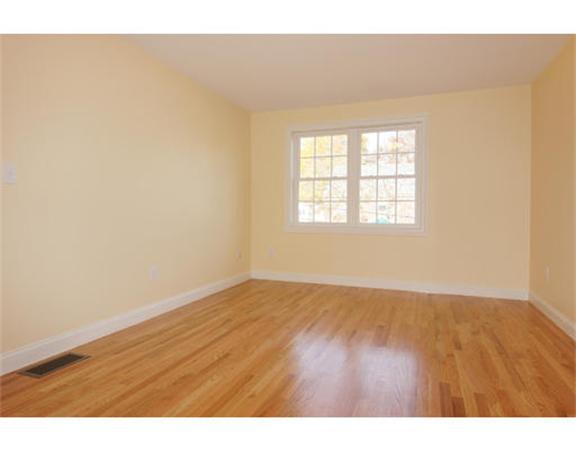 23 Mott Street, Unit 1 Arlington, MA 02474 - Photo 13 of 28 an empty room with wooden floor and windows