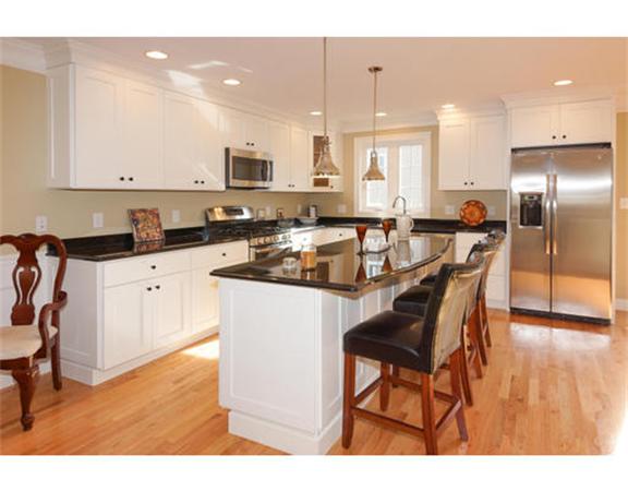 23 Mott Street, Unit 1 Arlington, MA 02474 - Photo 4 of 28 a kitchen with stainless steel appliances granite countertop a stove top oven a sink a refrigerator and white cabinets