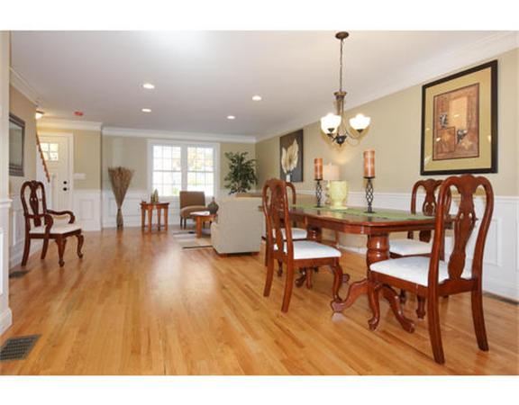 23 Mott Street, Unit 1 Arlington, MA 02474 - Photo 8 of 28 a dining room with wooden floor a chandelier a glass table and chairs