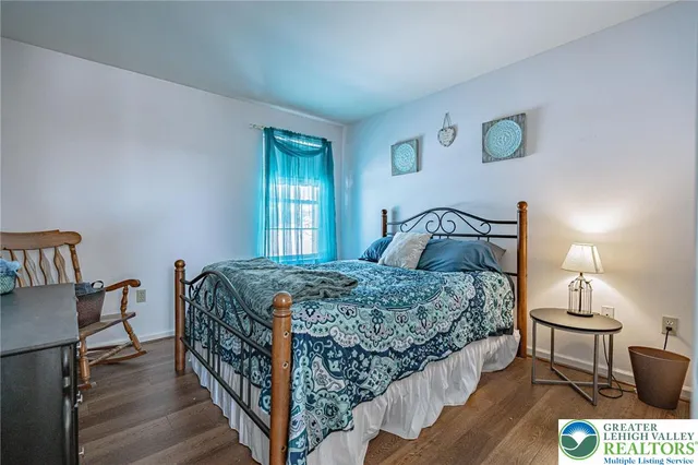 a bedroom with a large bed and wooden floor