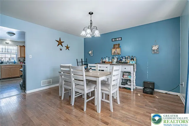 a view of a dining room with furniture wooden floor and a chandelier