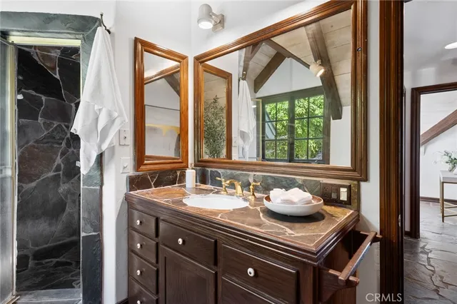 a bathroom with a granite countertop sink a large mirror and a bathtub