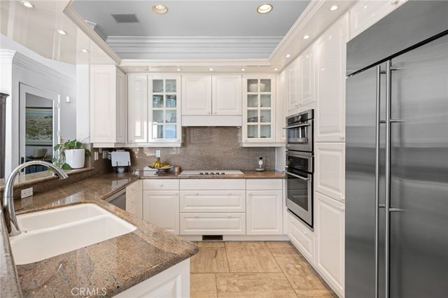 a kitchen with stainless steel appliances granite countertop a refrigerator and a sink