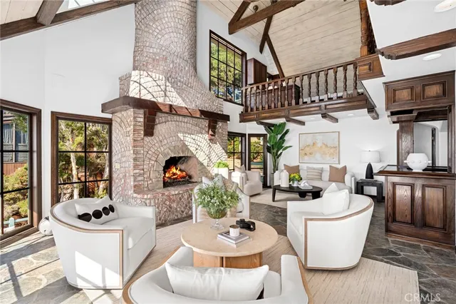 a living room with furniture a fireplace and a chandelier