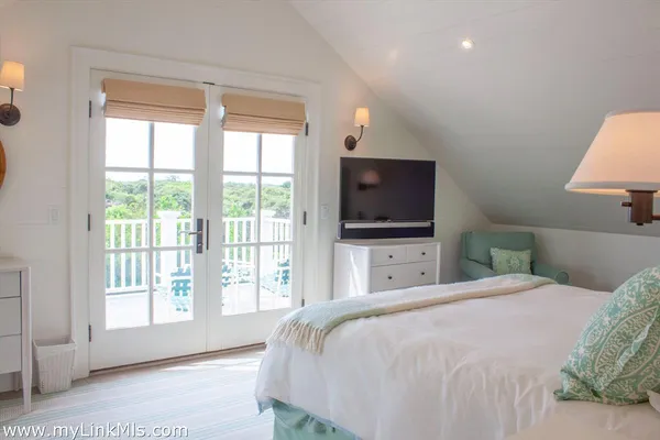 a bedroom with a flat screen tv and a toilet