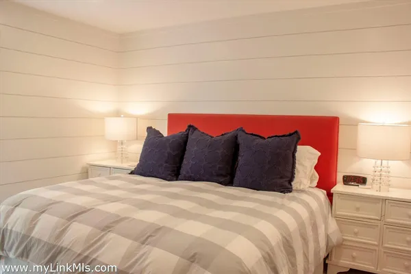 a large bed sitting in a bedroom next to a window