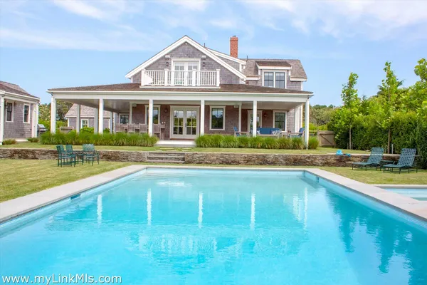 a front view of a house with swimming pool having outdoor seating