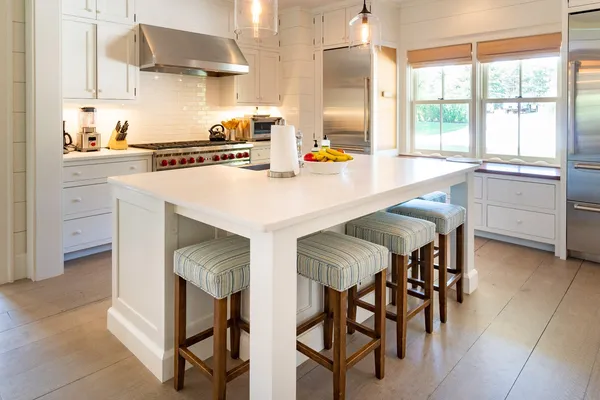a kitchen with a table chairs sink and cabinets