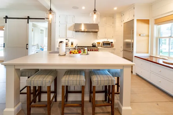 a kitchen with a table chairs refrigerator and microwave