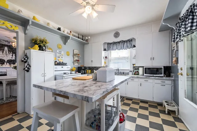 a view of staircase with lots of frames on wall and wooden floor