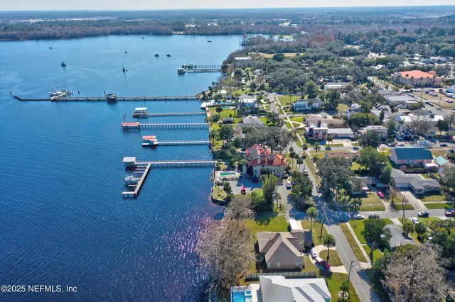 an aerial view of residential houses with outdoor space and parking