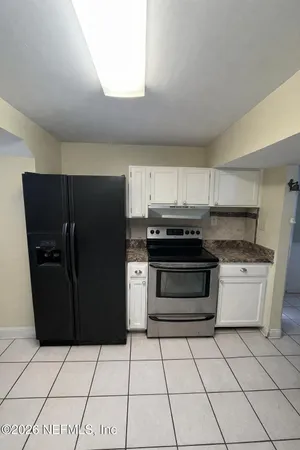 a bedroom with a bed and large windows