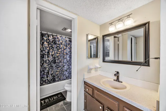 a bathroom with a sink vanity granite and toilet