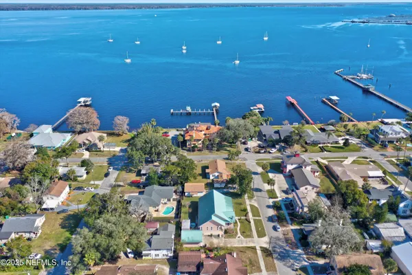an aerial view of residential houses with outdoor space and parking
