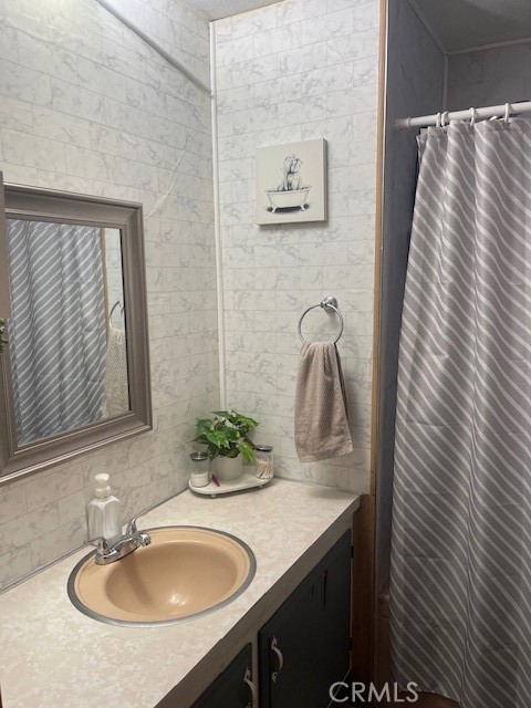 1560 Massachusetts Avenue, Unit 123 Riverside, CA 92507 - Photo 13 of 15 a bathroom with a granite countertop sink and a mirror