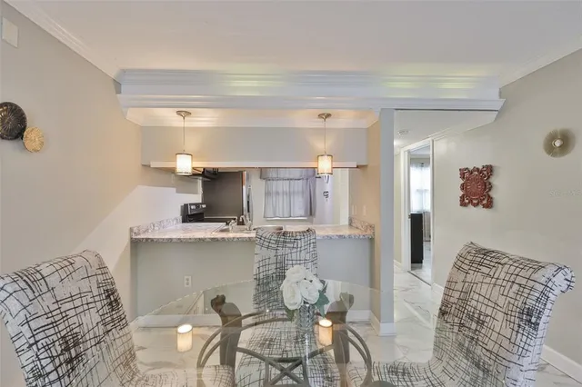 a kitchen with a dining table chairs and a refrigerator