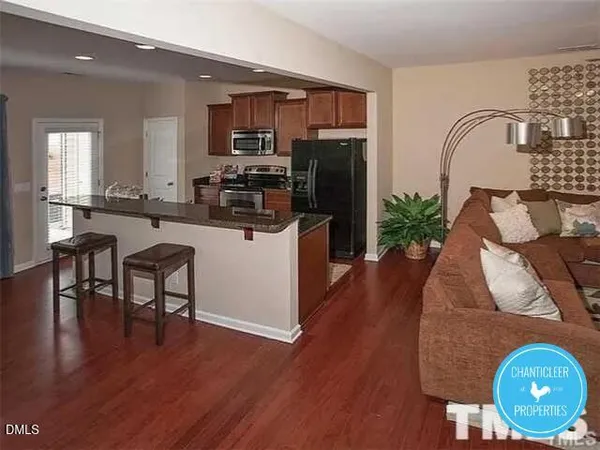 a kitchen with furniture wooden floor and a refrigerator
