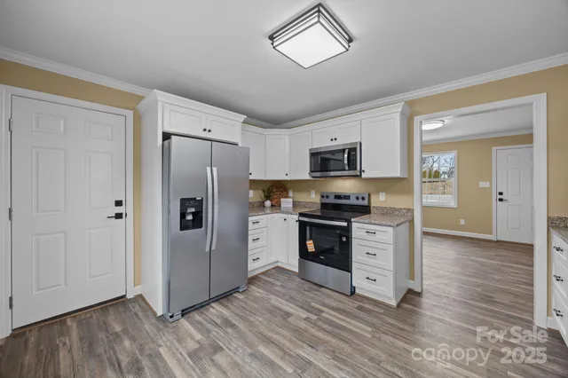 a kitchen with granite countertop a refrigerator and a stove top oven