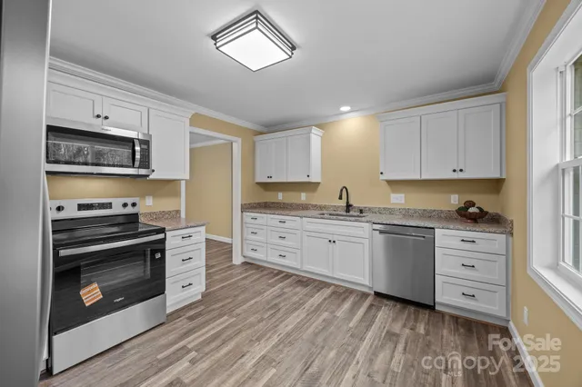 a kitchen with granite countertop a stove cabinets and refrigerator
