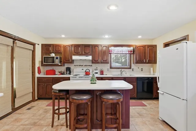 a kitchen with stainless steel appliances a refrigerator sink and white cabinets