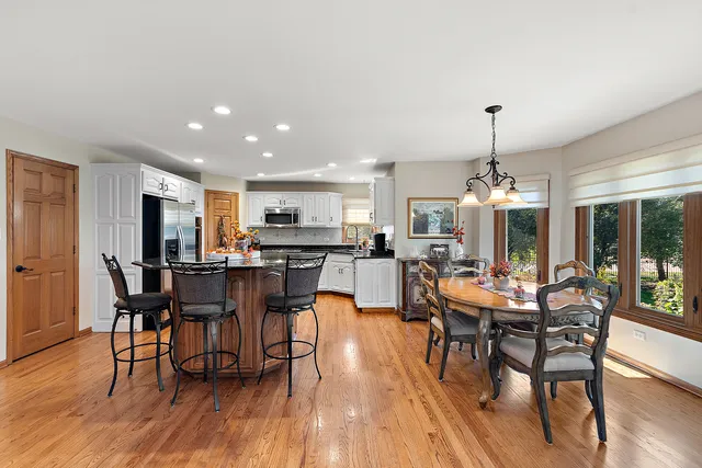 a kitchen with a dining table chairs appliances and cabinets