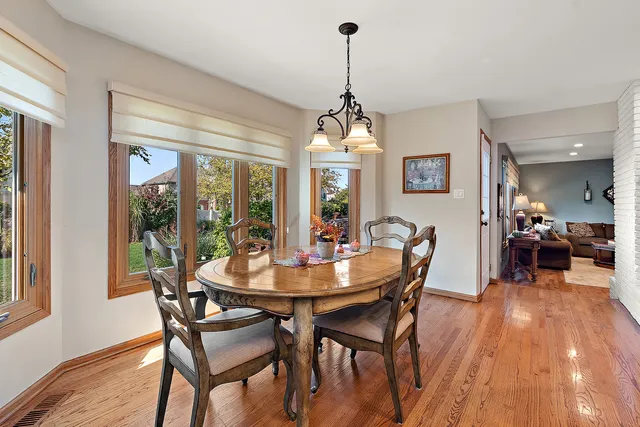 a room with stainless steel appliances lots of furniture and wooden floors