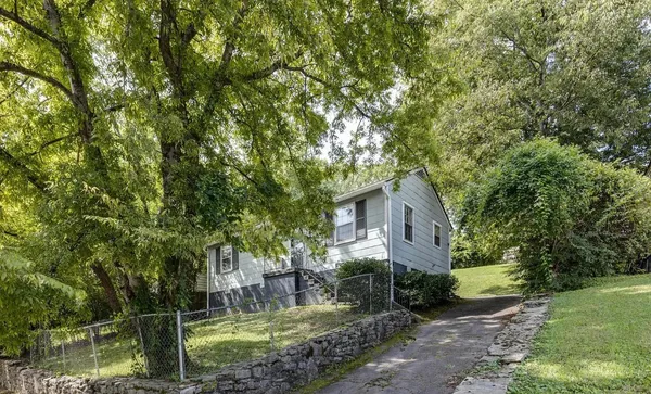 a front view of a house with a yard and tree s