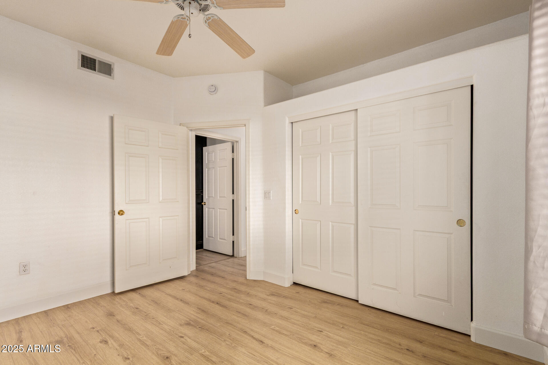 7101 West Beardsley Road, Unit 451 Glendale, AZ 85308 - Photo 15 of 26 an empty room with wooden floor a ceiling fan and windows