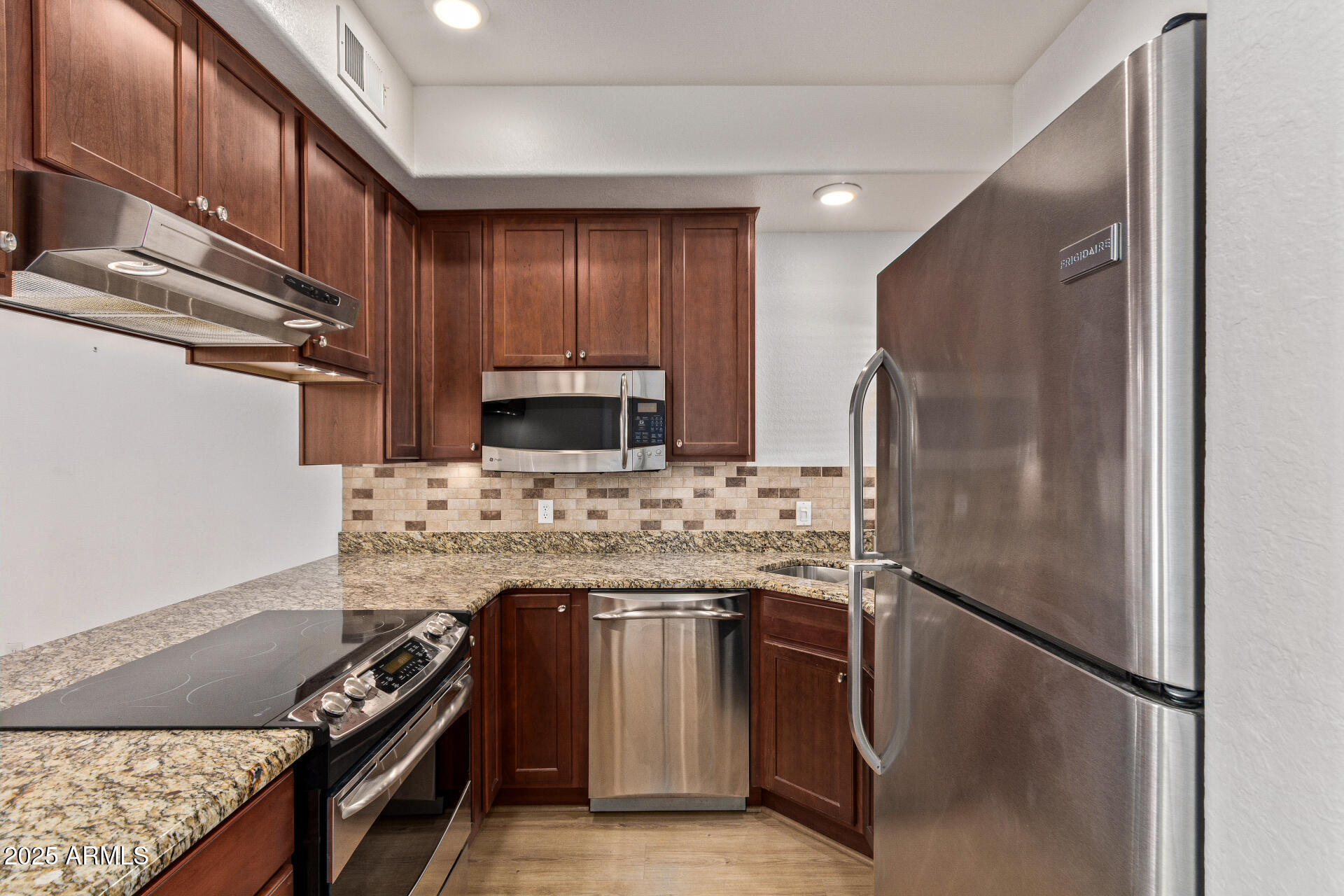 7101 West Beardsley Road, Unit 451 Glendale, AZ 85308 - Photo 17 of 26 a kitchen with stainless steel appliances granite countertop a refrigerator and a stove