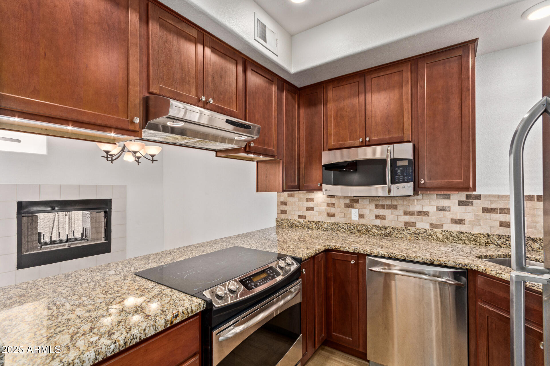 7101 West Beardsley Road, Unit 451 Glendale, AZ 85308 - Photo 18 of 26 a kitchen with stainless steel appliances granite countertop a stove a sink and a microwave