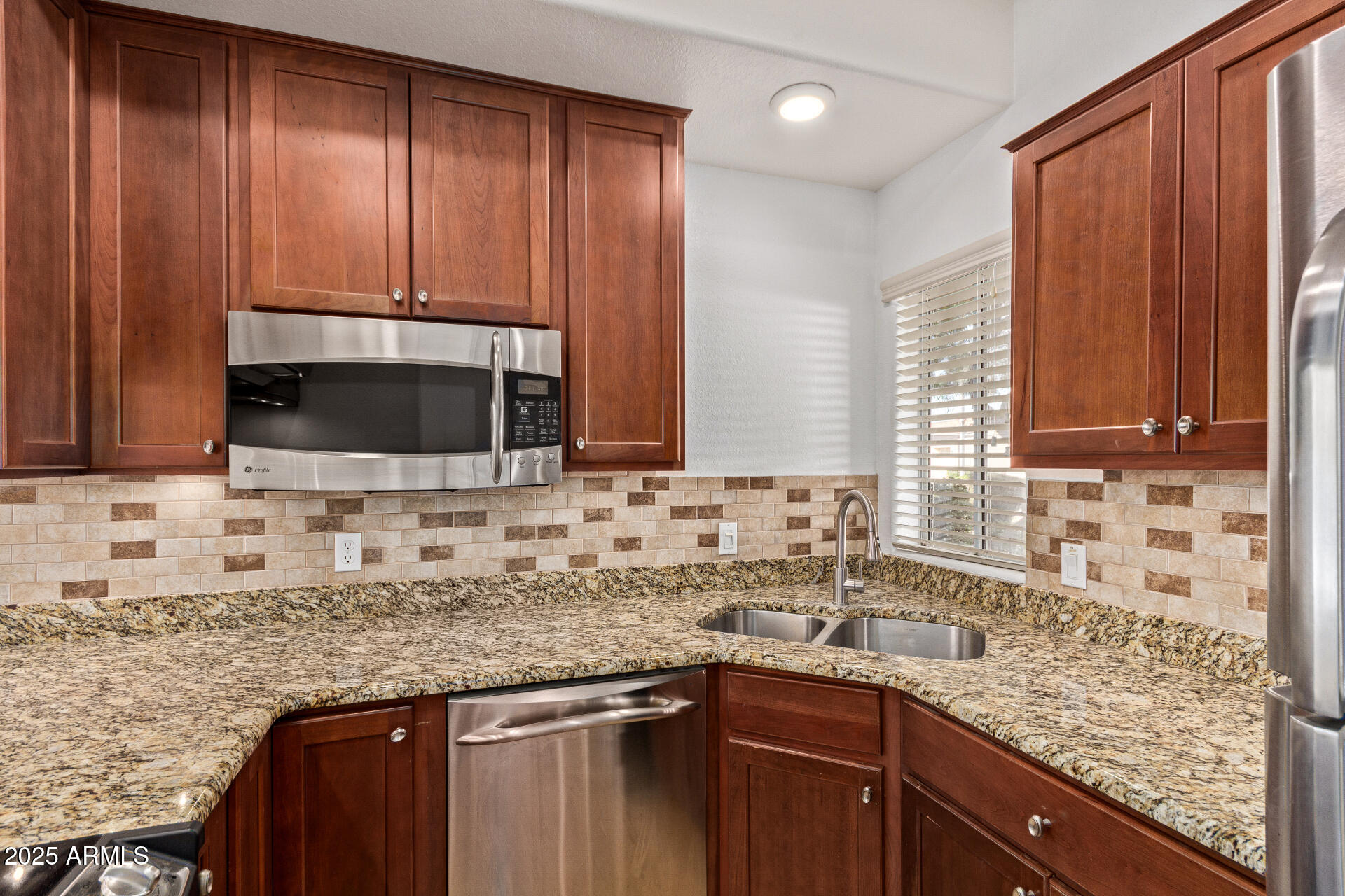 7101 West Beardsley Road, Unit 451 Glendale, AZ 85308 - Photo 19 of 26 a kitchen with granite countertop stainless steel appliances a sink window and cabinets