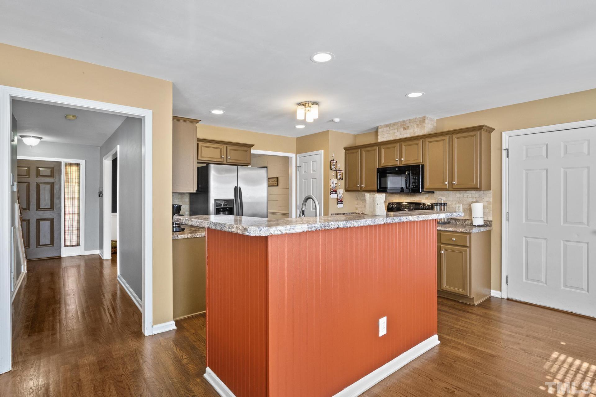 117 Mendel Drive Smithfield, NC 27577 - Photo 13 of 39 a kitchen with stainless steel appliances a refrigerator a stove a microwave and wooden floor