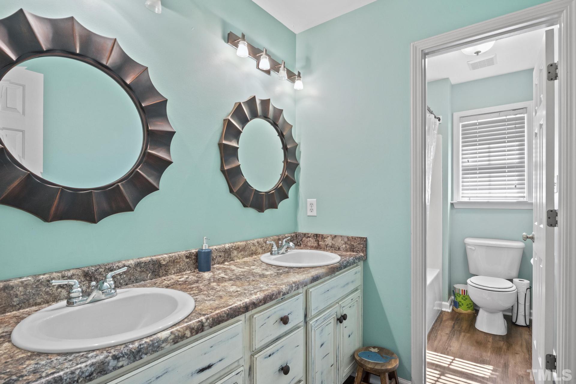 117 Mendel Drive Smithfield, NC 27577 - Photo 34 of 39 a bathroom with a granite countertop toilet a sink and a mirror