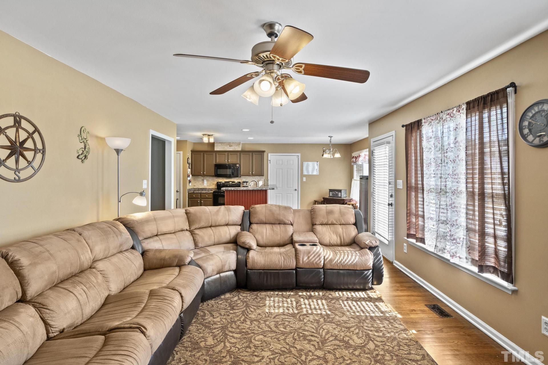 117 Mendel Drive Smithfield, NC 27577 - Photo 8 of 39 a living room with furniture ceiling fan and a rug
