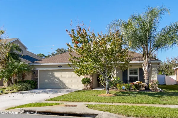 a front view of a house with a yard and trees