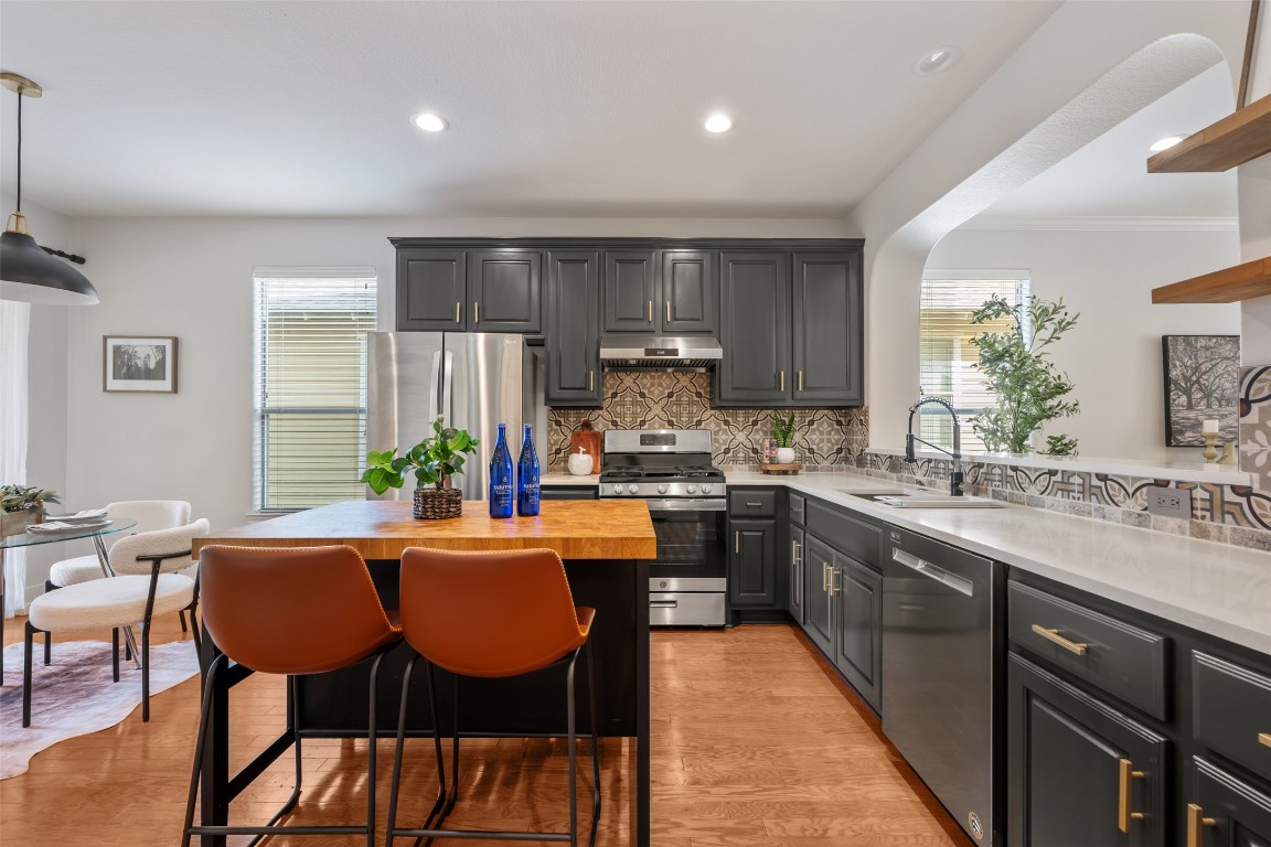 6020 Rutledge Lane Austin, TX 78745 - Photo 19 of 40 a kitchen with granite countertop a dining table chairs and white appliances