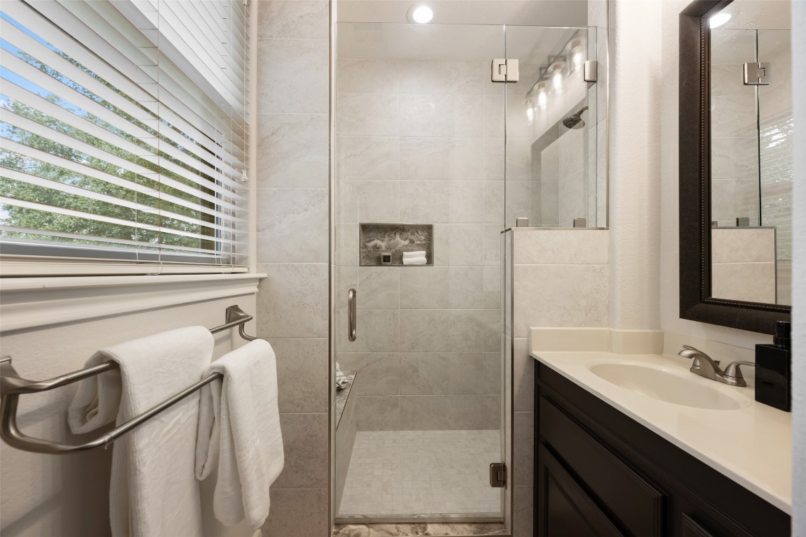 6020 Rutledge Lane Austin, TX 78745 - Photo 31 of 40 a bathroom with a double vanity sink a toilet a mirror and shower