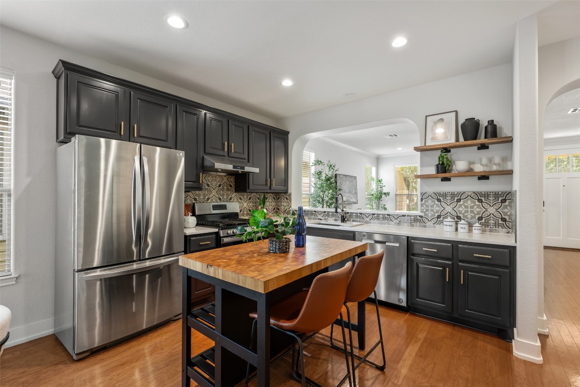 6020 Rutledge Lane Austin, TX 78745 - Photo 4 of 40 a kitchen with granite countertop a refrigerator and wooden cabinets