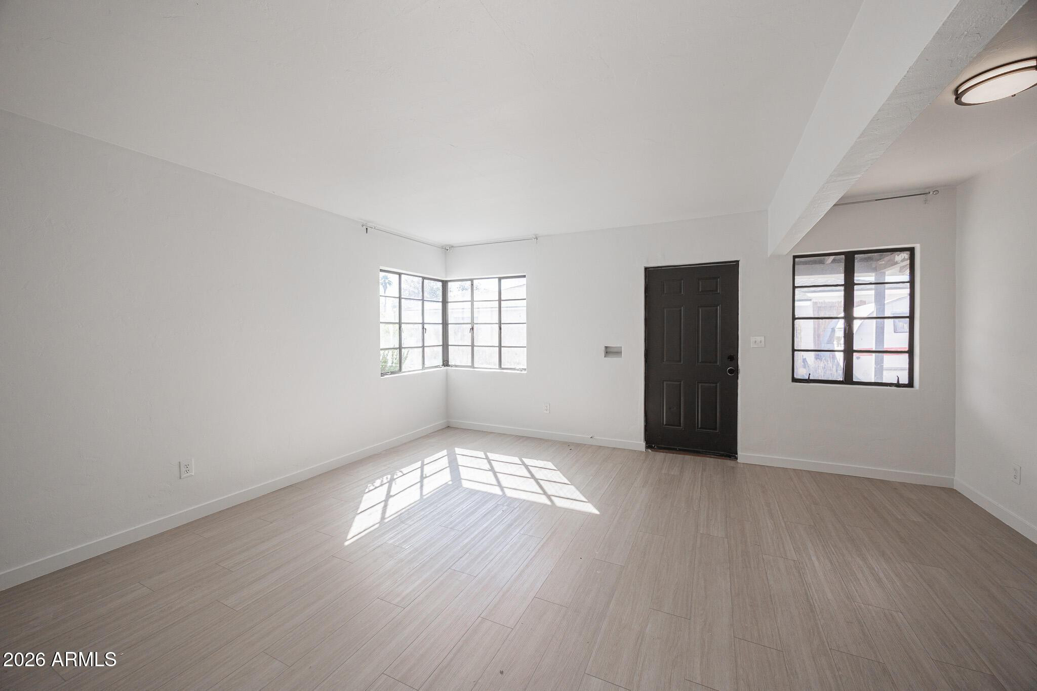 414 West 13th Street Tempe, AZ 85281 - Photo 6 of 21 an empty room with wooden floor and windows
