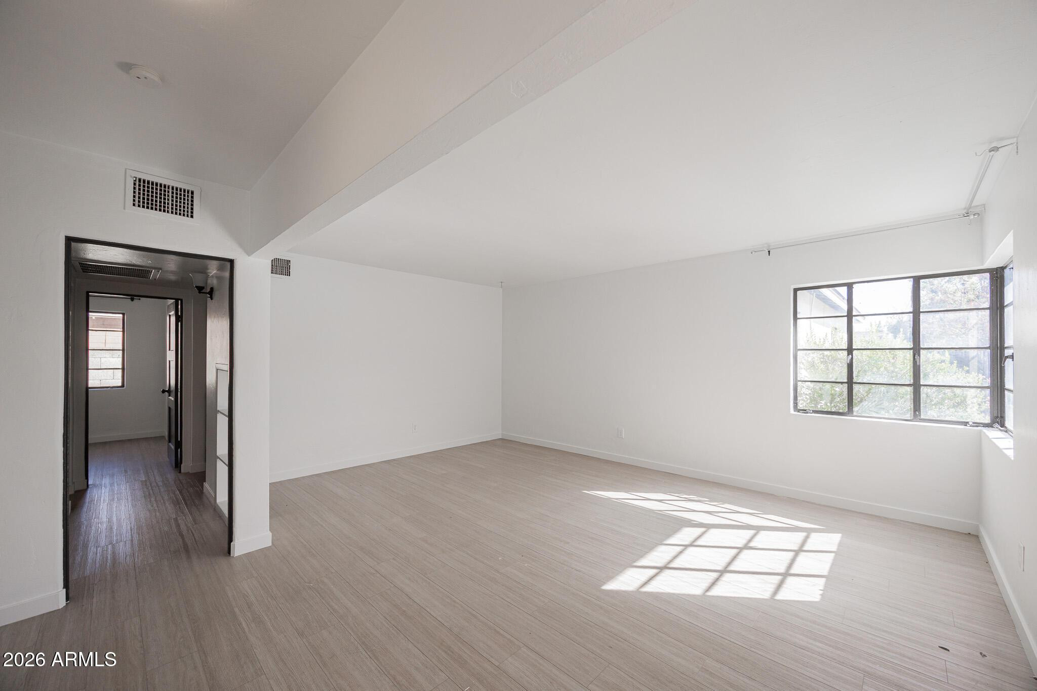 414 West 13th Street Tempe, AZ 85281 - Photo 7 of 21 an empty room with wooden floor and windows