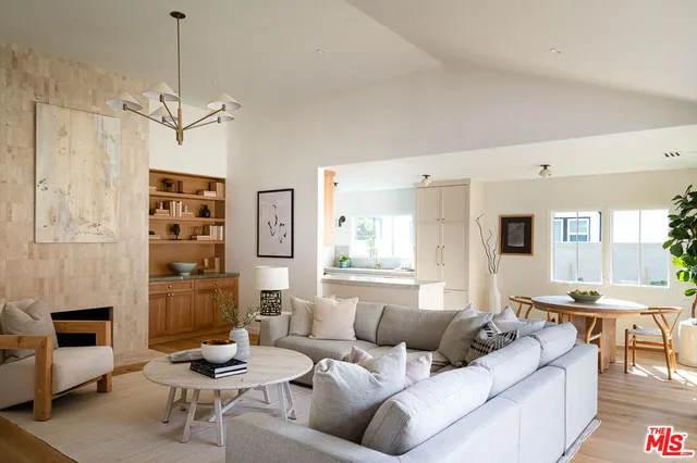 a living room with furniture a fireplace and a chandelier