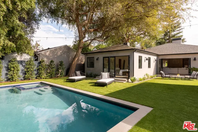 a backyard of a house with table and chairs