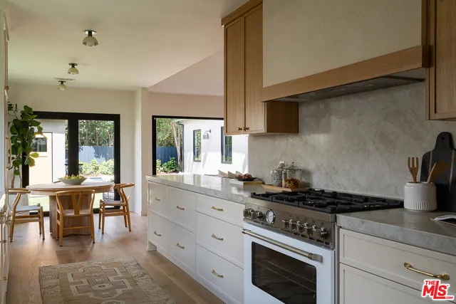 a kitchen with a stove and white cabinets