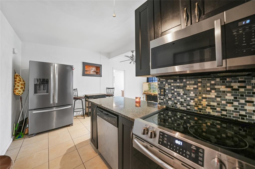 2321 Dallas Street Port Charlotte, FL 33952 - Photo 10 of 38 a kitchen with granite countertop a stove and a microwave