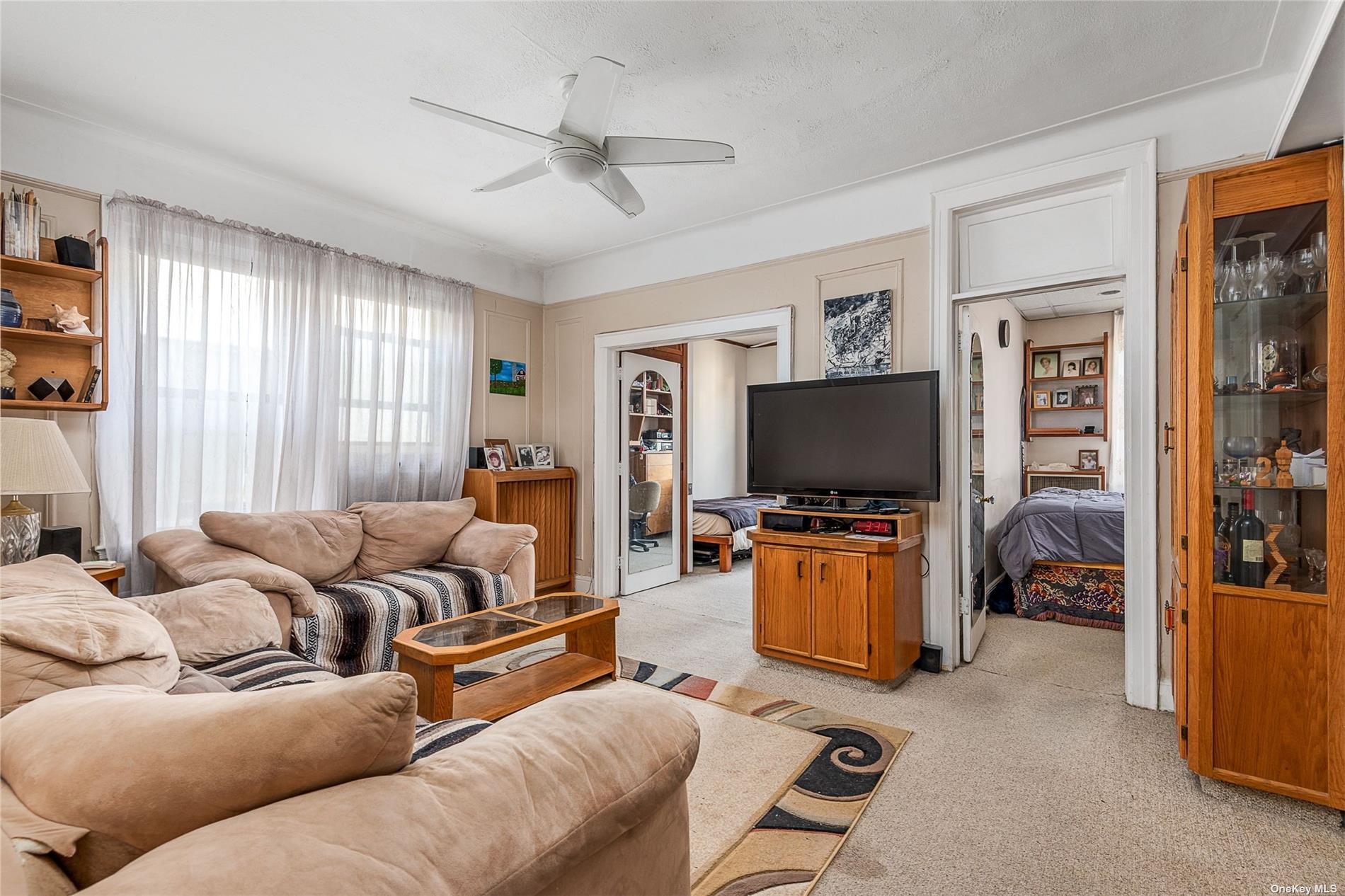 37-68 64th Street Queens, NY 11377 - Photo 2 of 12 a living room with furniture and a flat screen tv