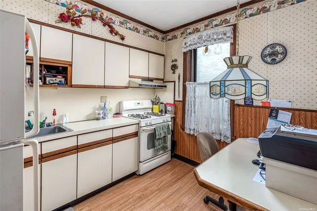 a kitchen with stainless steel appliances granite countertop a sink cabinets and wooden floor