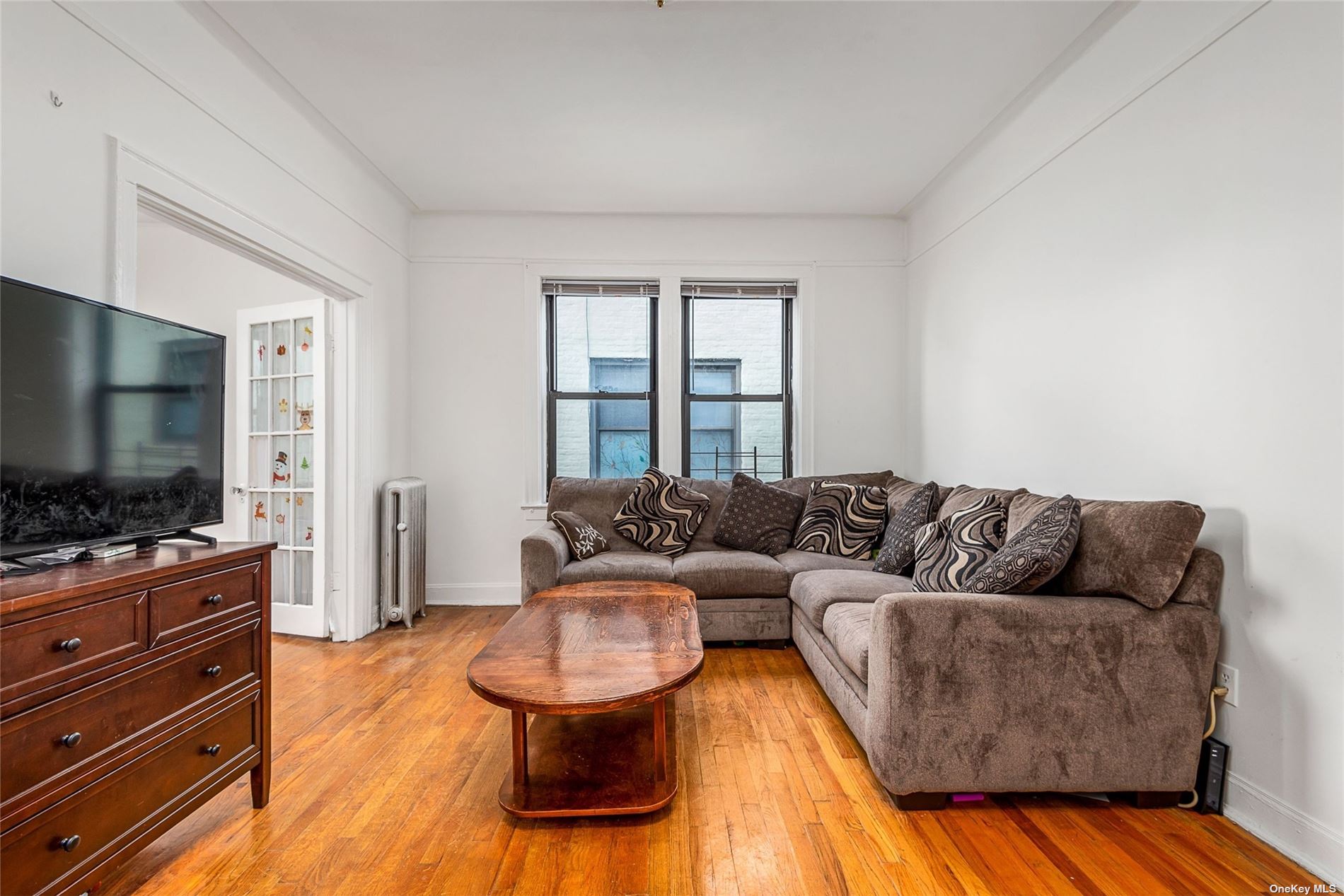 37-68 64th Street Queens, NY 11377 - Photo 8 of 12 a living room with furniture and a flat screen tv